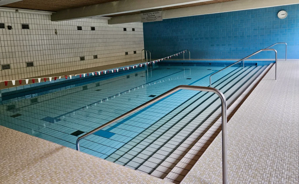 Leeres Schwimmbad mit blauen Fliesen.